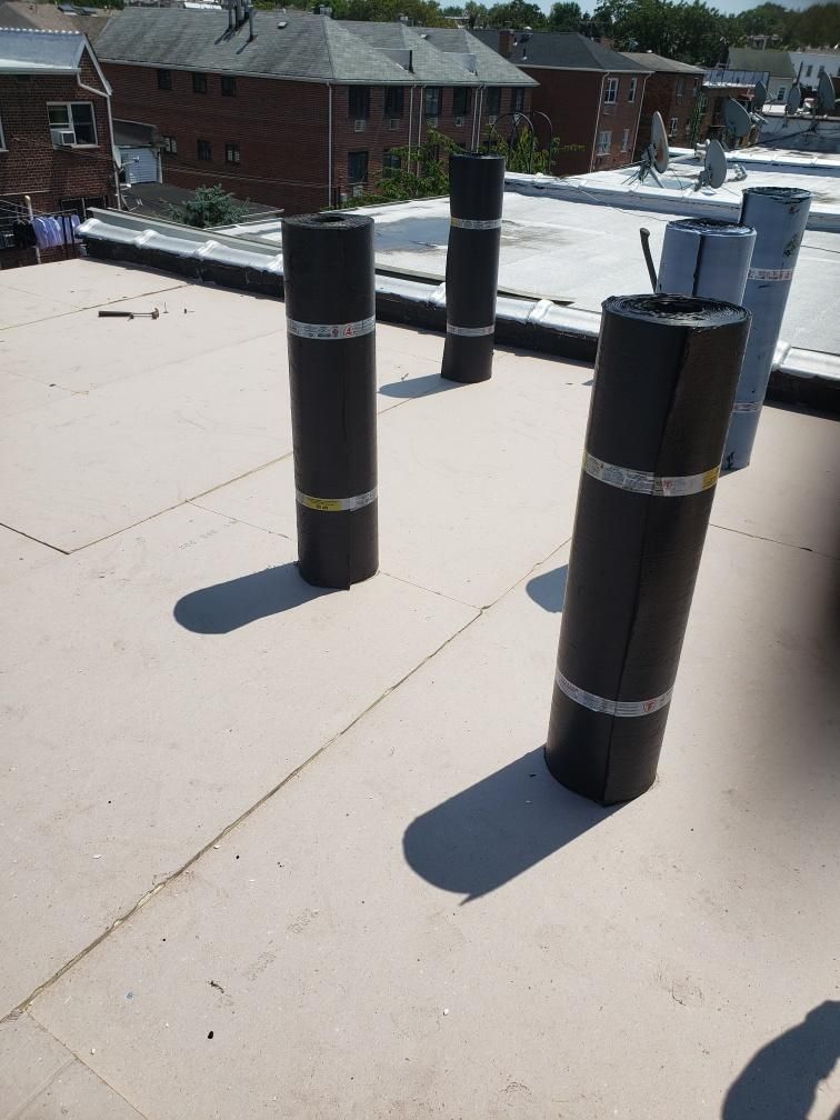 A roof with a lot of rolls of roofing material on it