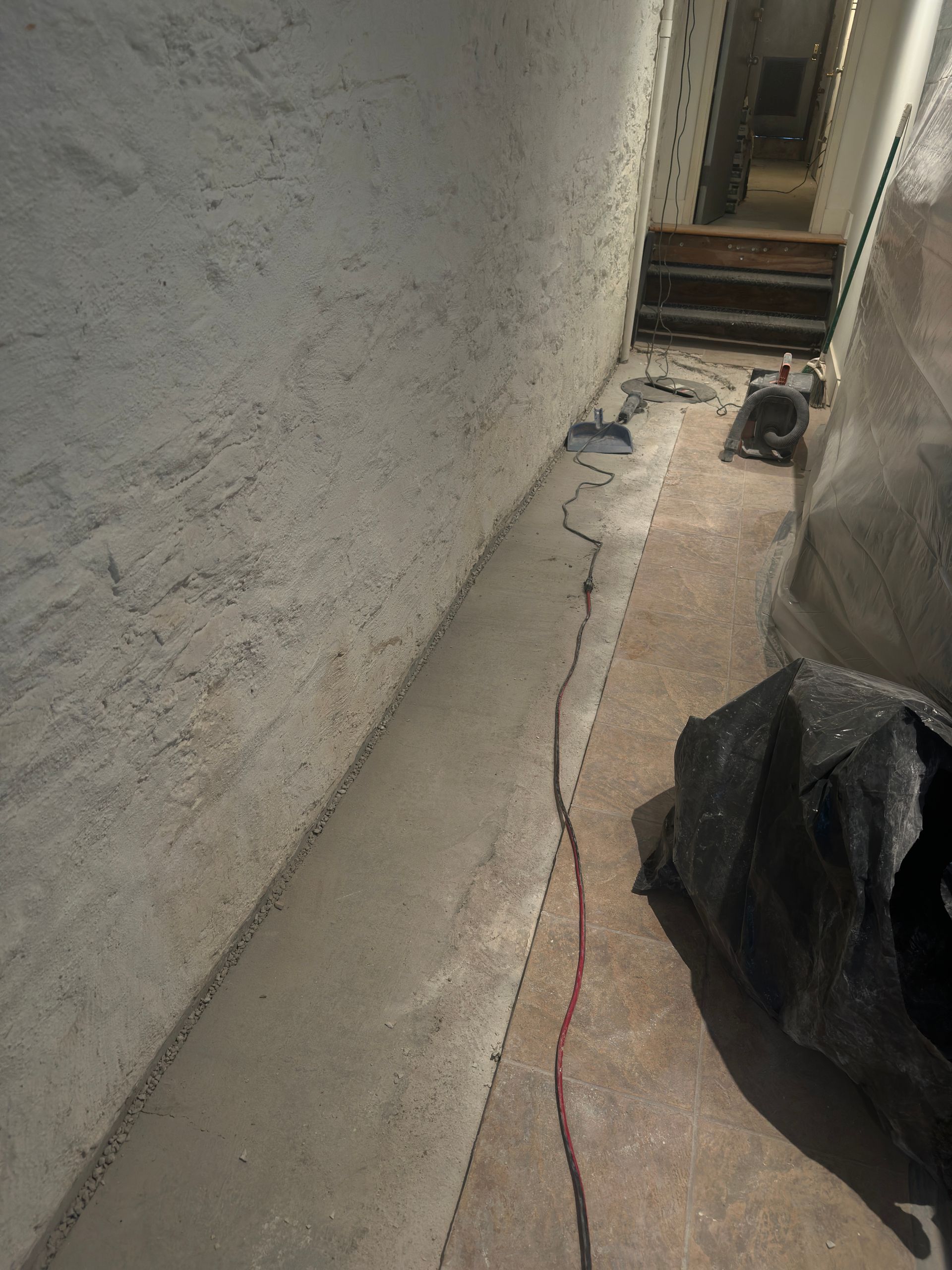 A concrete floor with a red cord coming out of it.