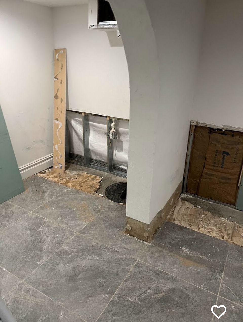 A room with a heart drawn on the floor and a hole in the wall.