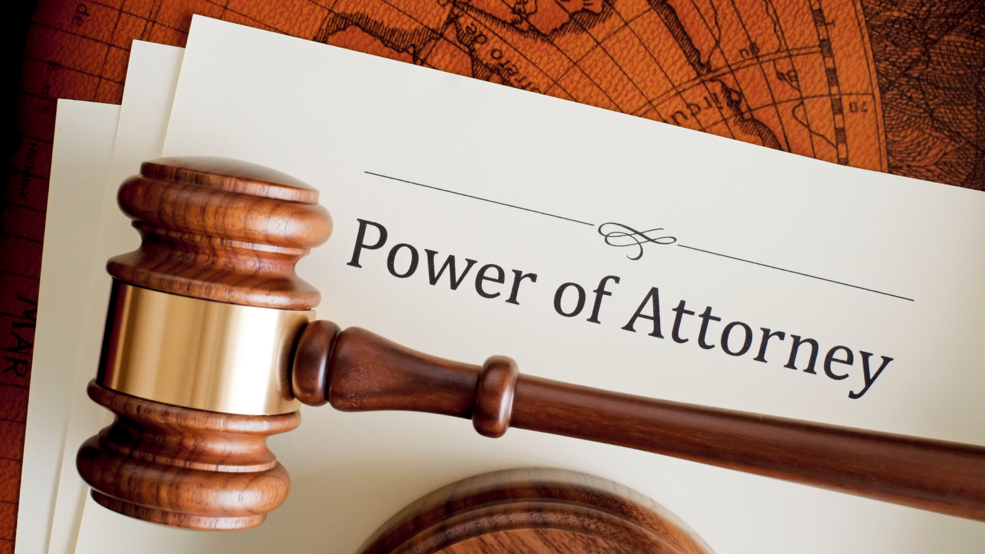 A wooden gavel is sitting on top of a power of attorney