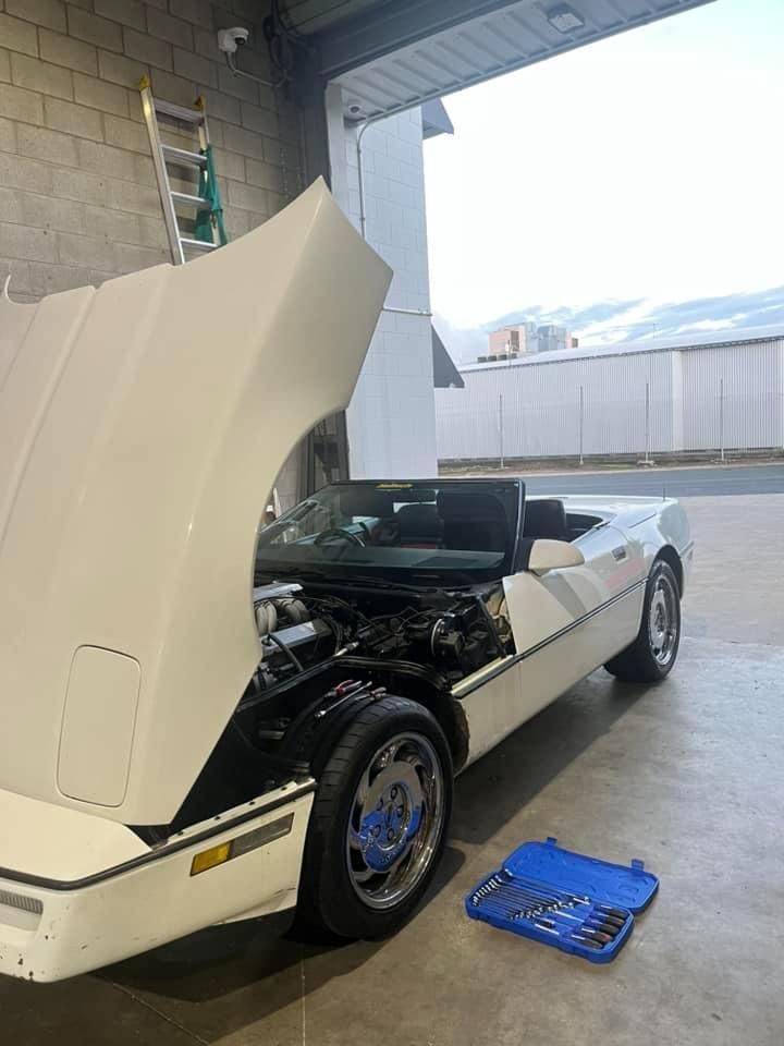 A White Car With the Hood Up is Parked in a Garage — BA Auto Electrical In West Mackay, QLD