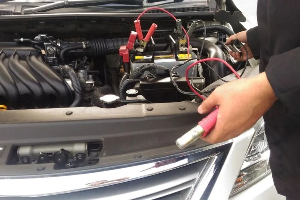 A Person is Charging a Car Battery With Jumper Cables — BA Auto Electrical In West Mackay, QLD