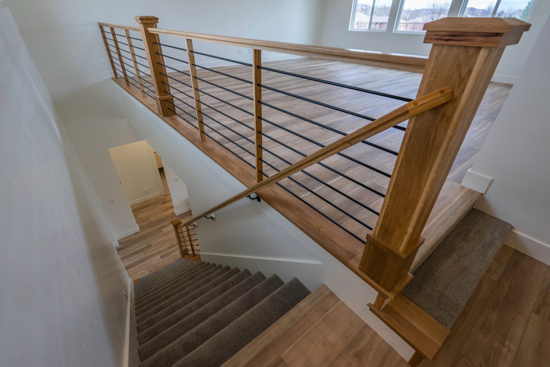 A wooden staircase with a metal railing in a house.
