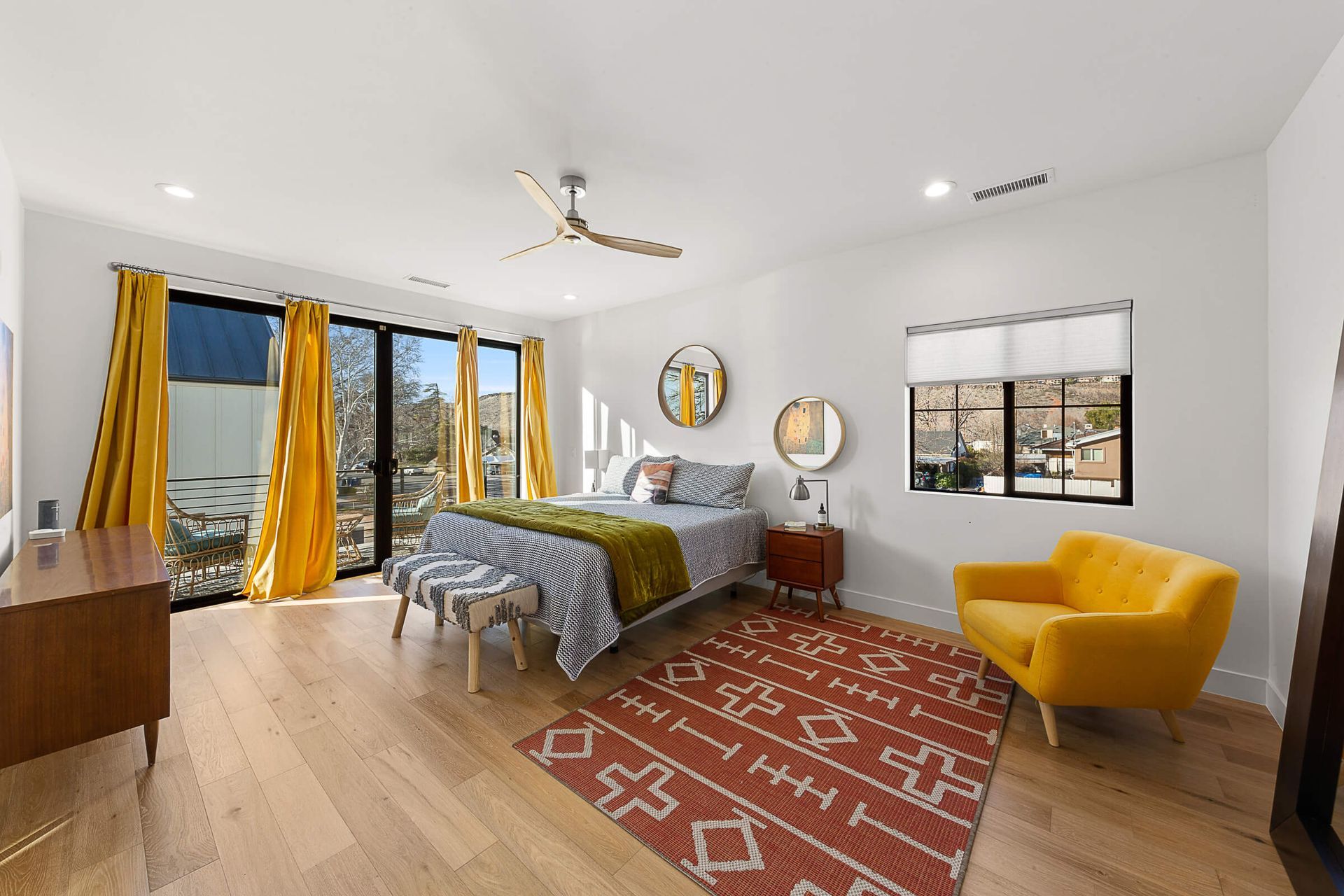 A bedroom with a bed , chair , dresser and window.