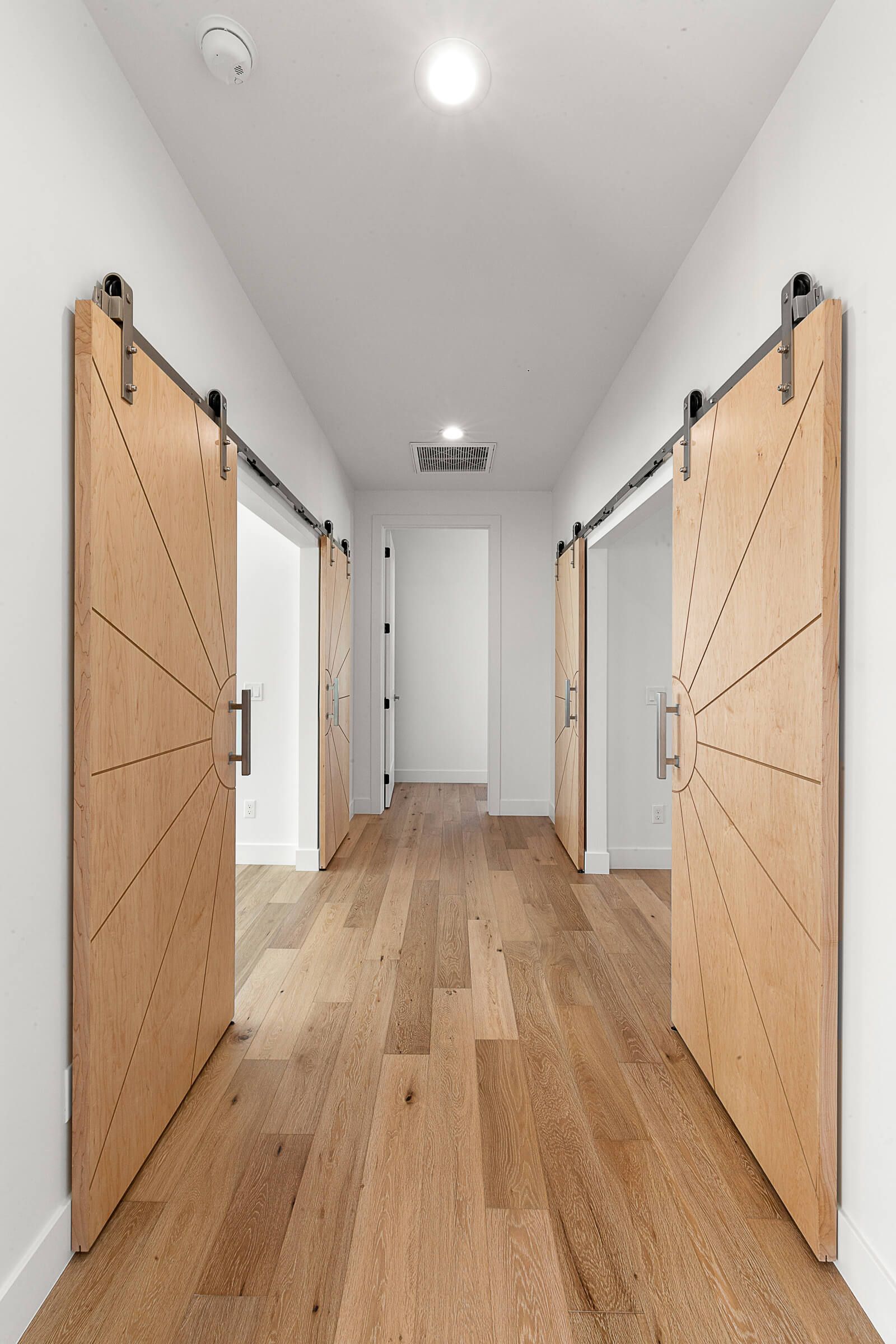 A hallway with wooden floors and sliding barn doors