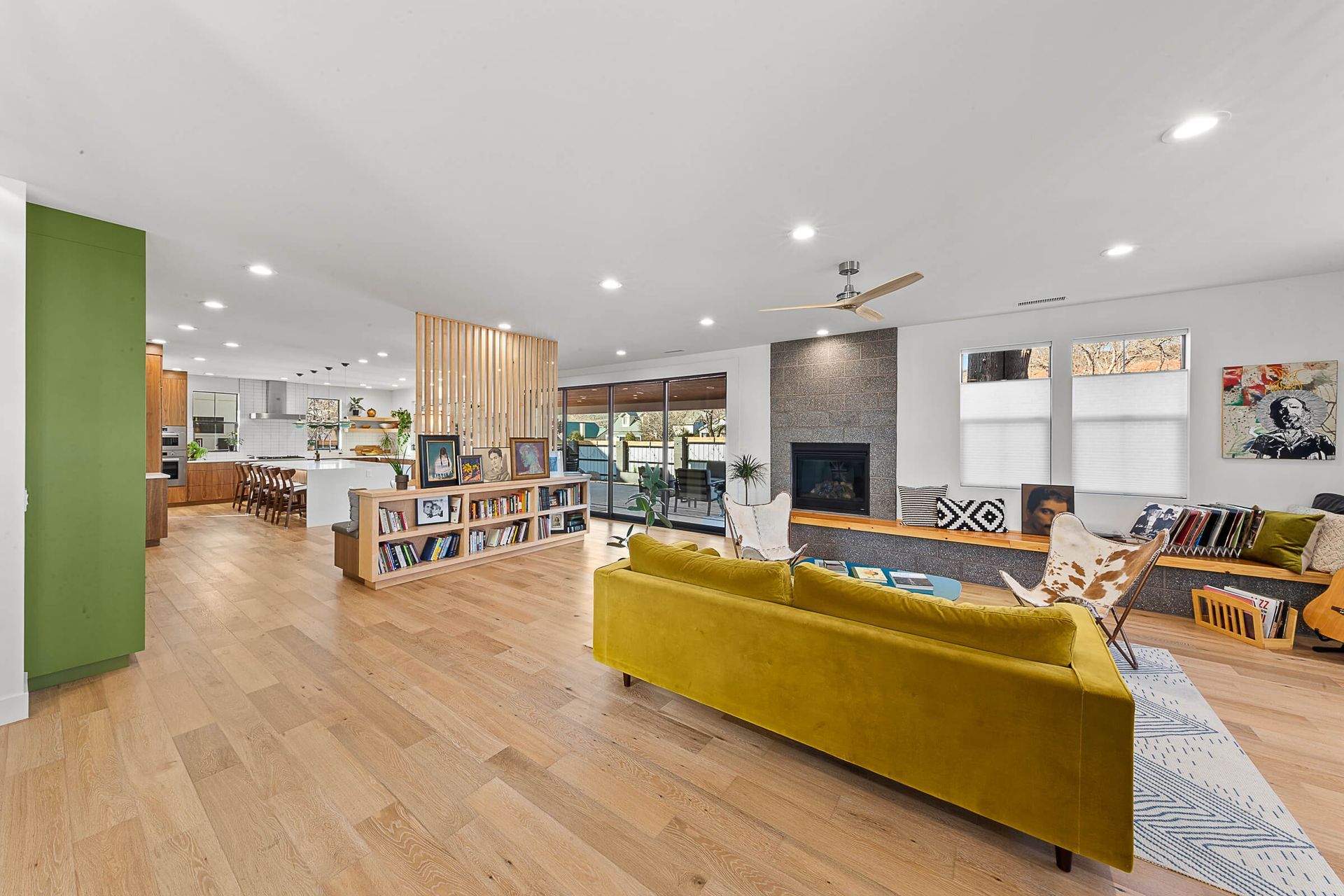 A living room with a yellow couch and a fireplace.