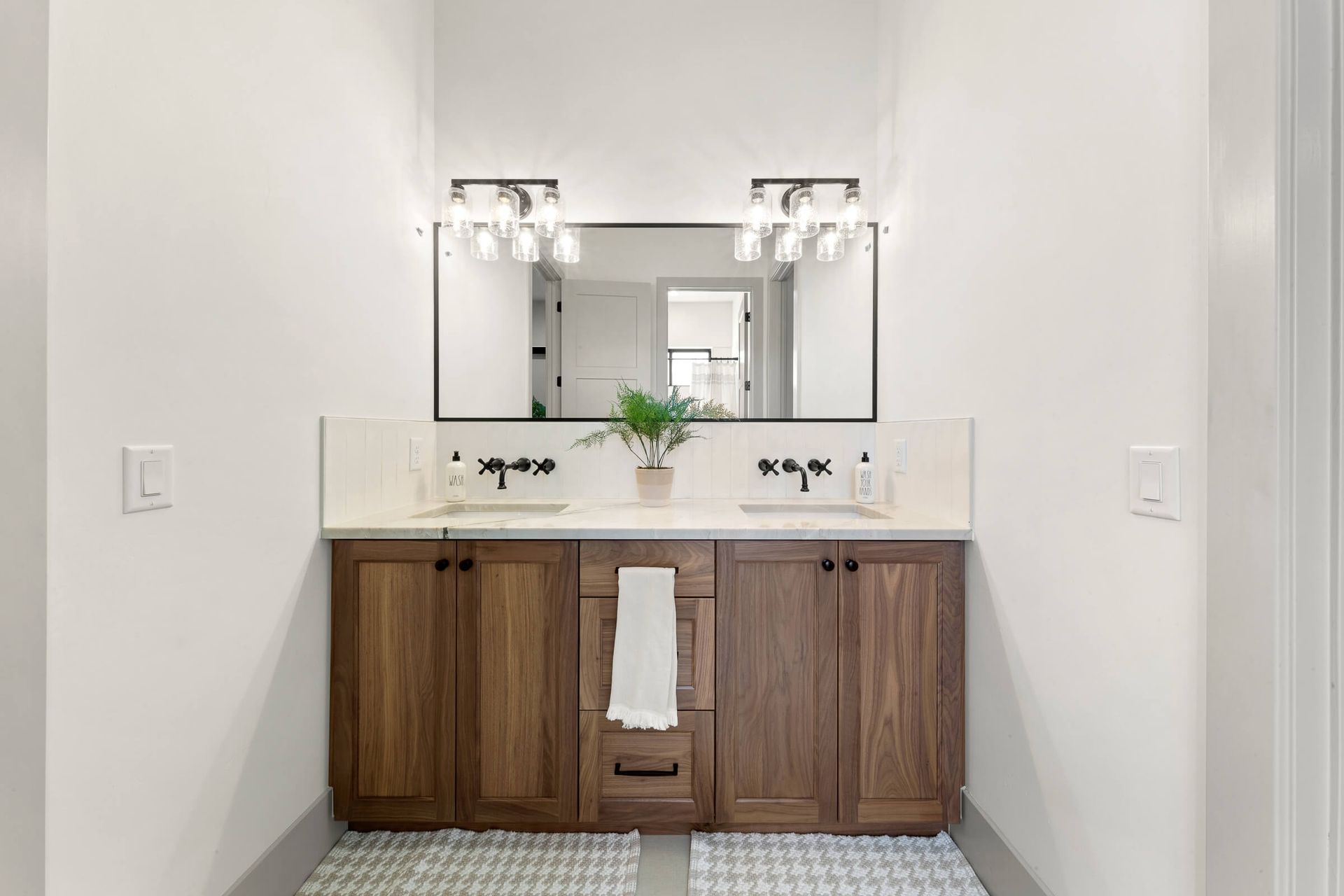 A bathroom with two sinks and a large mirror.