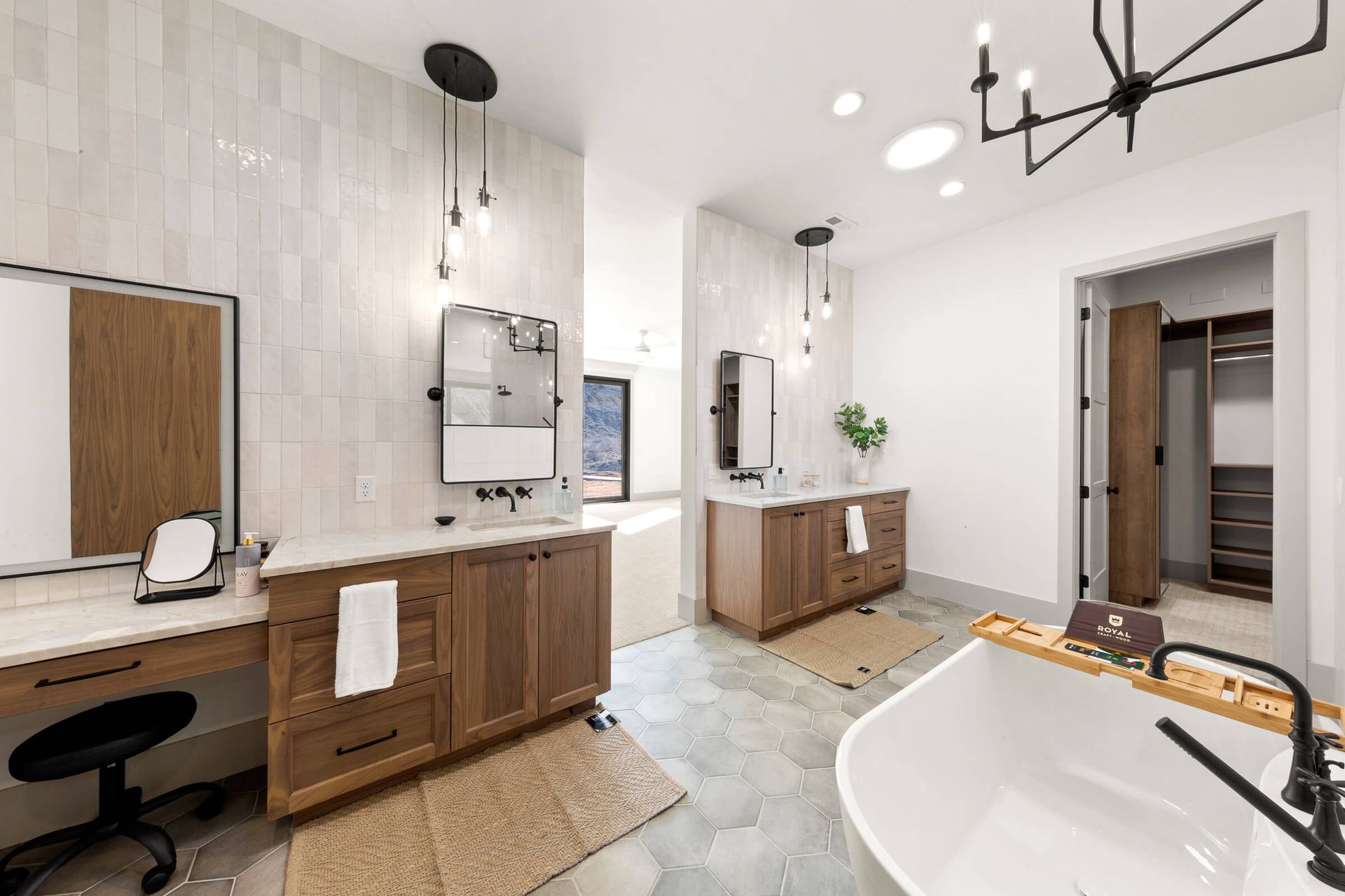 A bathroom with two sinks , a tub and a mirror.