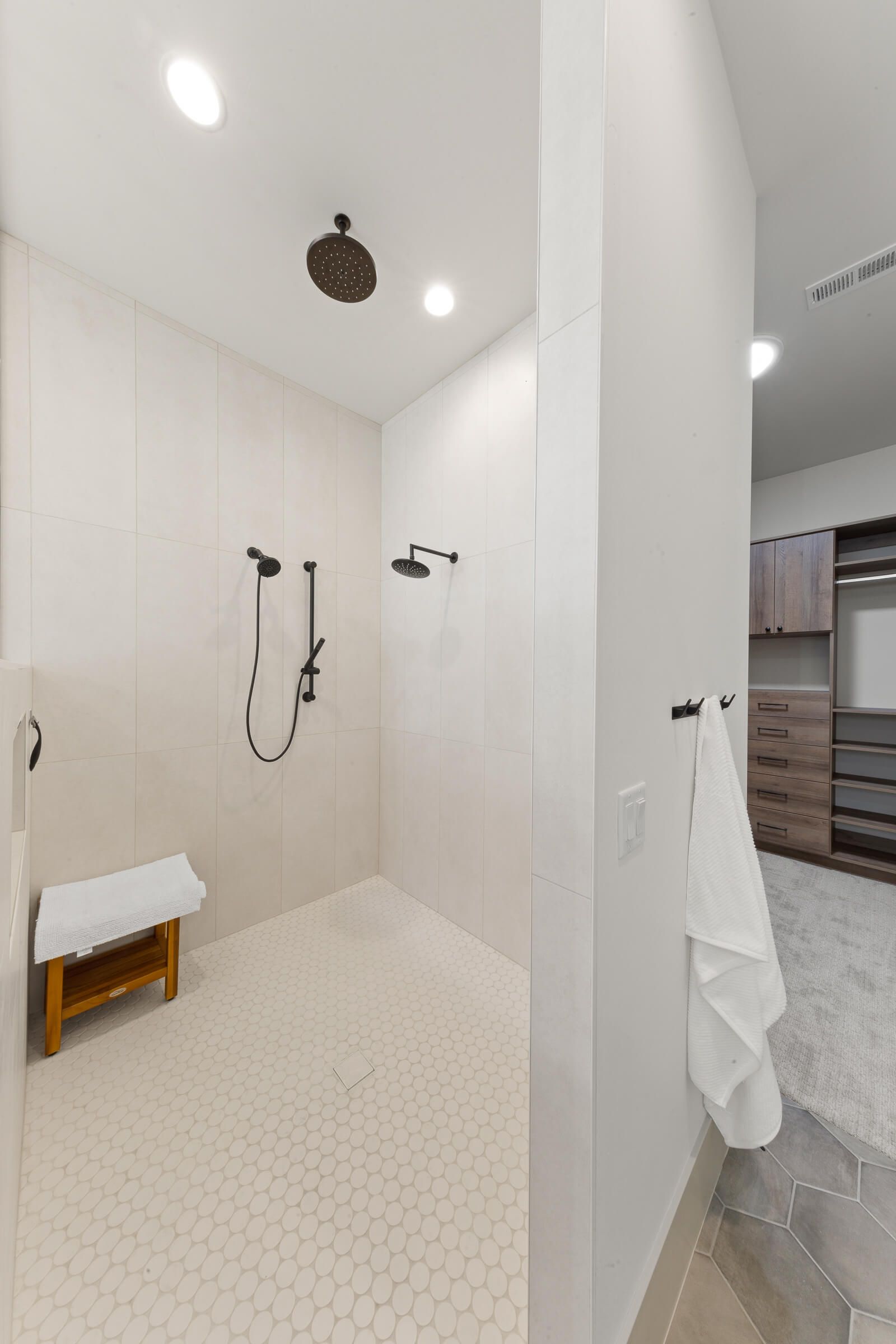 A bathroom with a walk in shower and a bench.