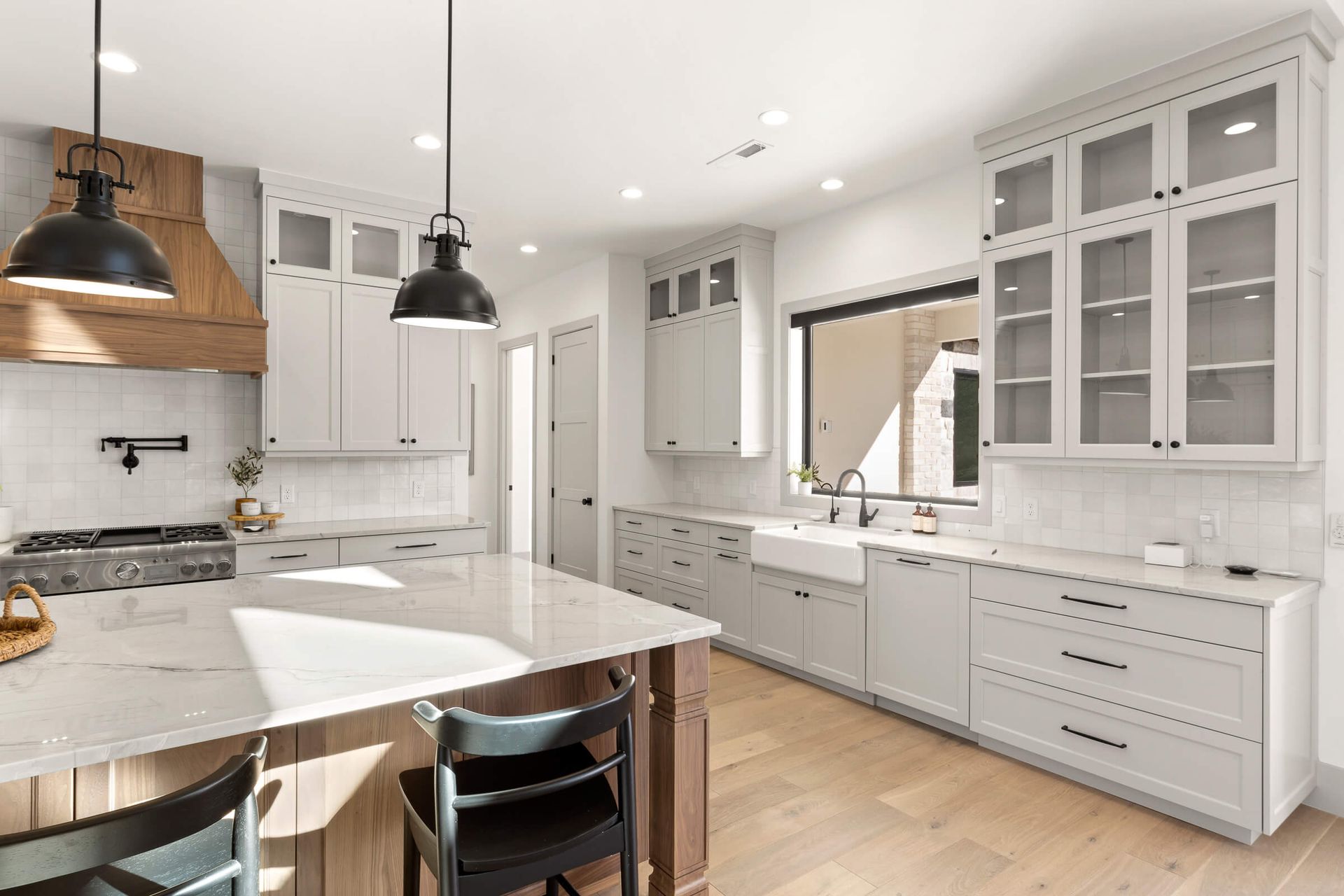 A kitchen with white cabinets , granite counter tops , and a large island.