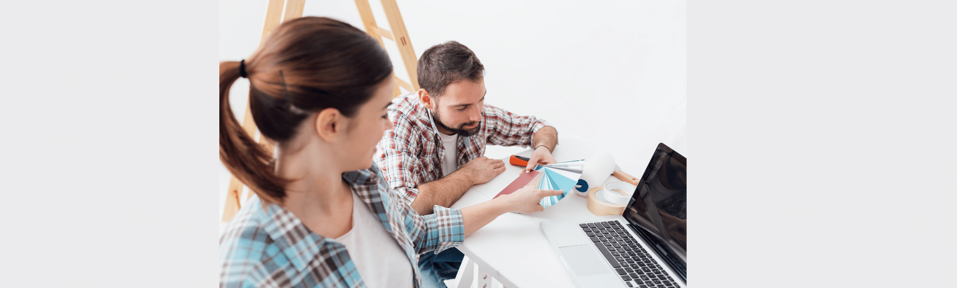 A man and a woman are sitting at a table with a laptop.