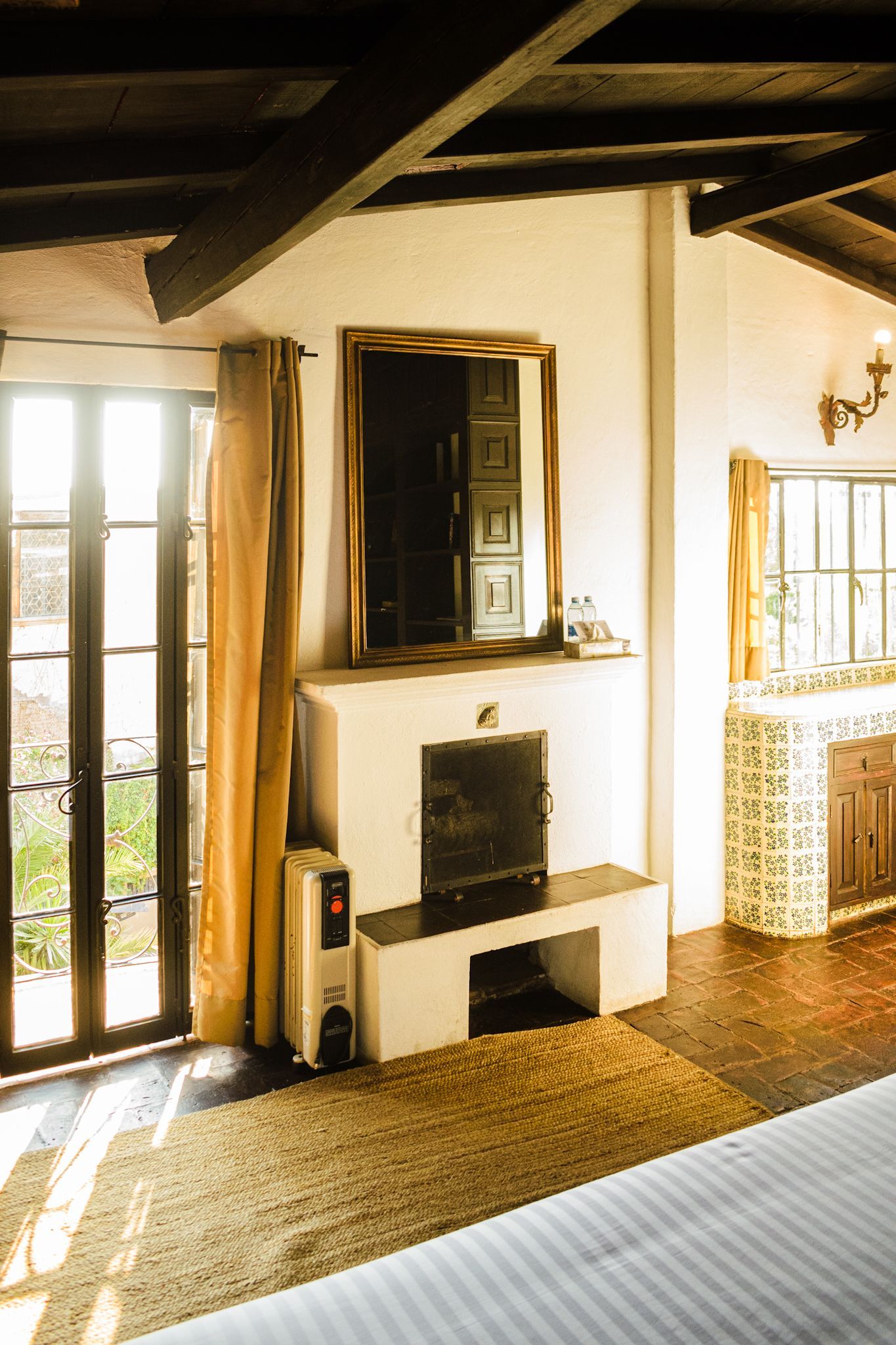 Acogedora habitación con chimenea, paredes blancas, vigas de madera.