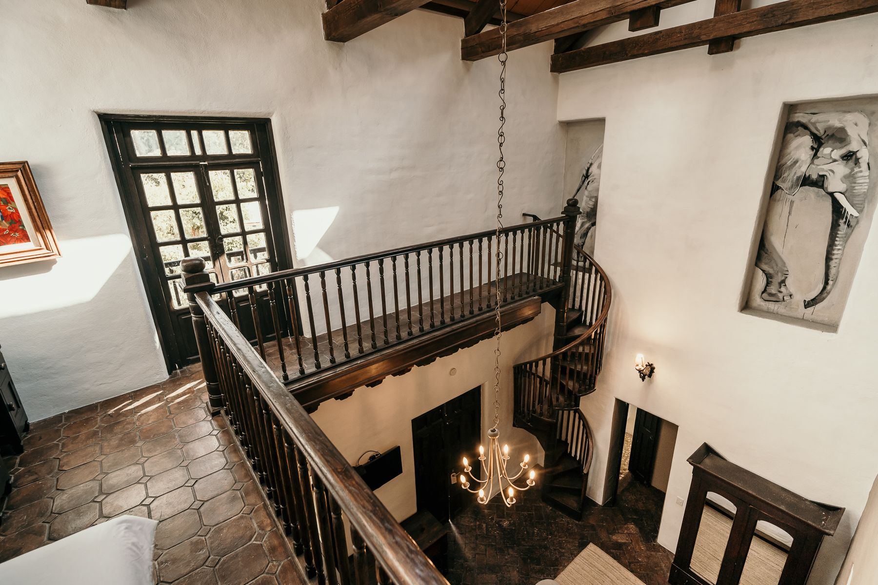 Vista interior de una casa con balcón y escalera de caracol.