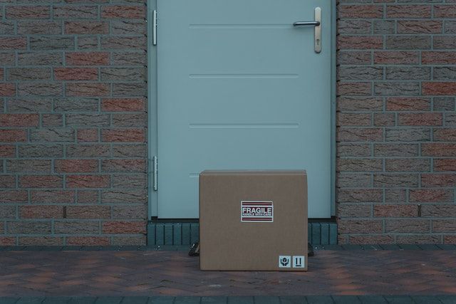 a package with a fragile label on it sitting outside a blue door