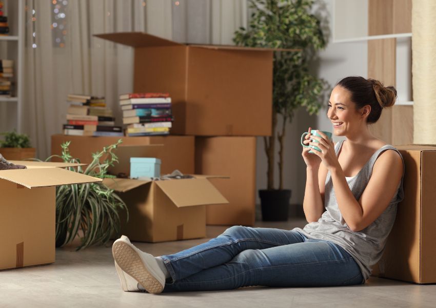 person-sitting-on-boxes-drinking