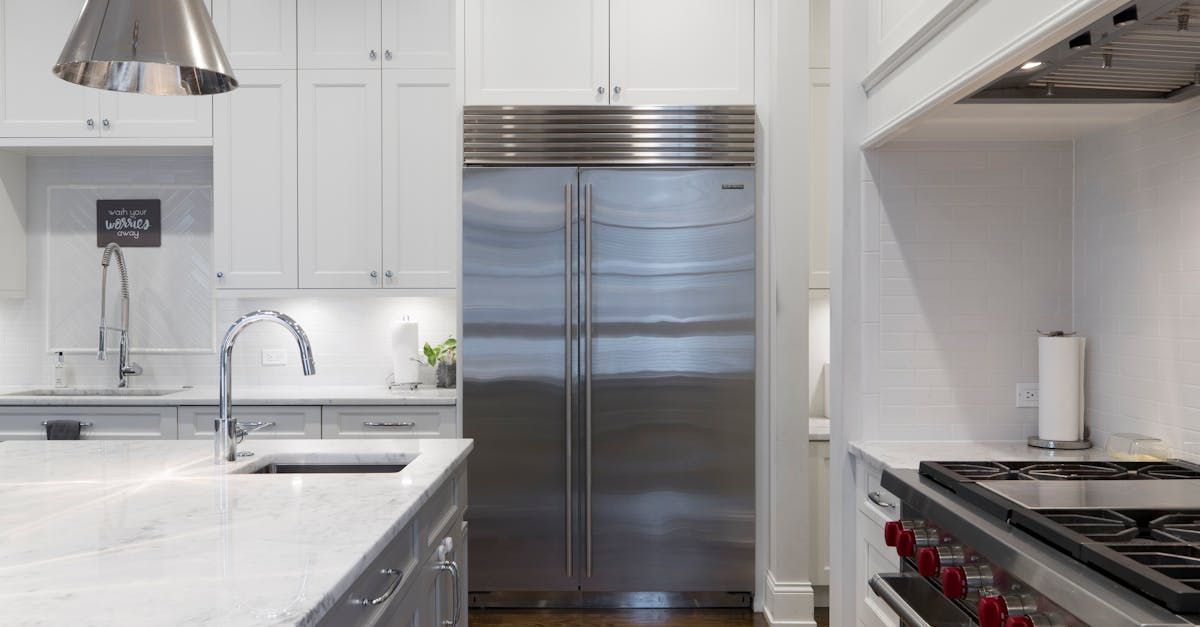 A kitchen with stainless steel appliances and white cabinets.