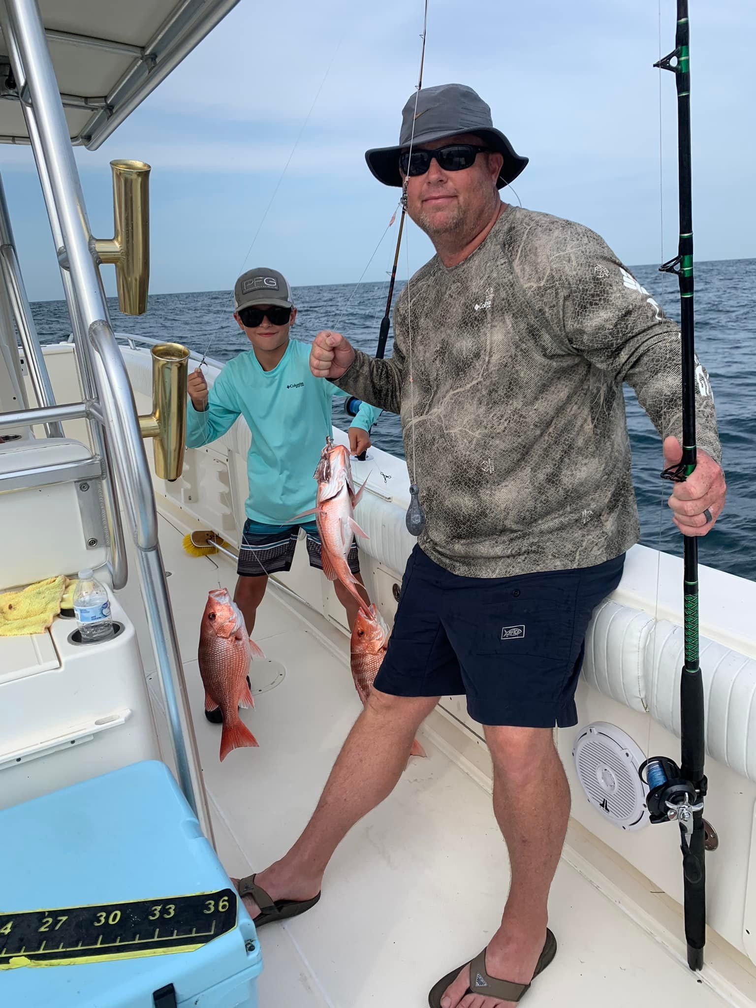 Two men are fishing on a boat in the ocean.