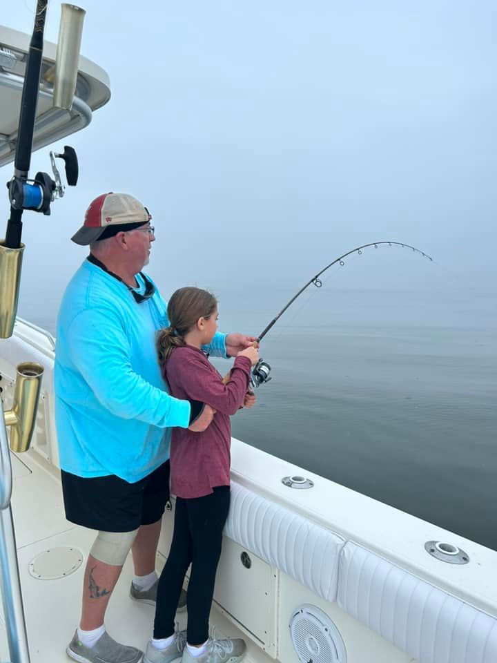 A man and a girl are fishing on a boat.