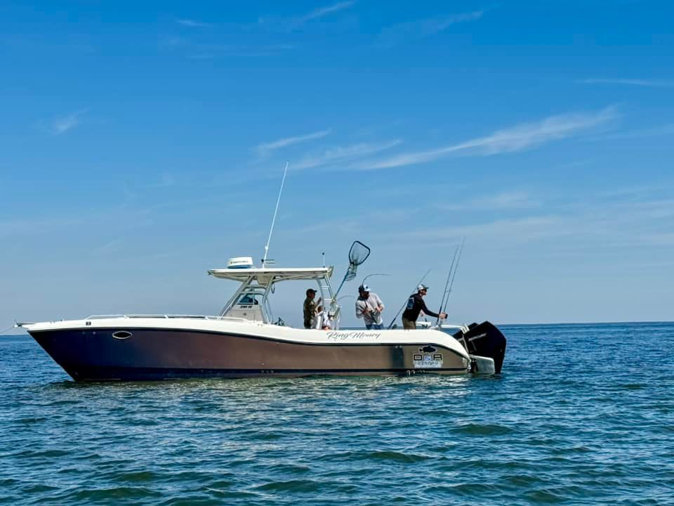 A group of people are fishing on a boat in the ocean.