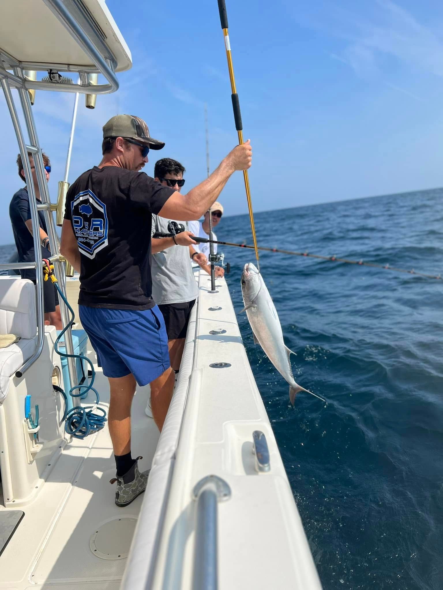 A group of men are fishing on a boat in the ocean.