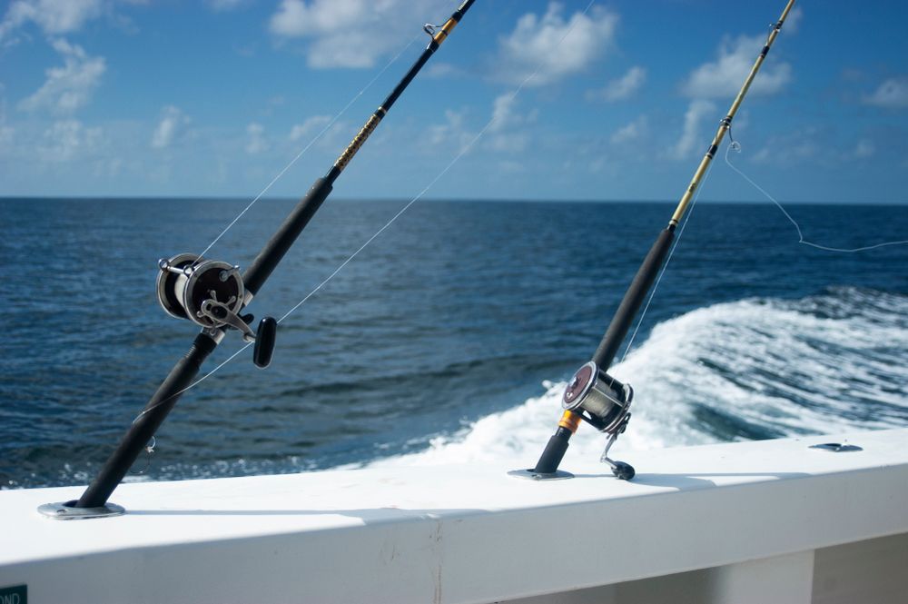 Two fishing rods are sitting on a boat in the ocean.
