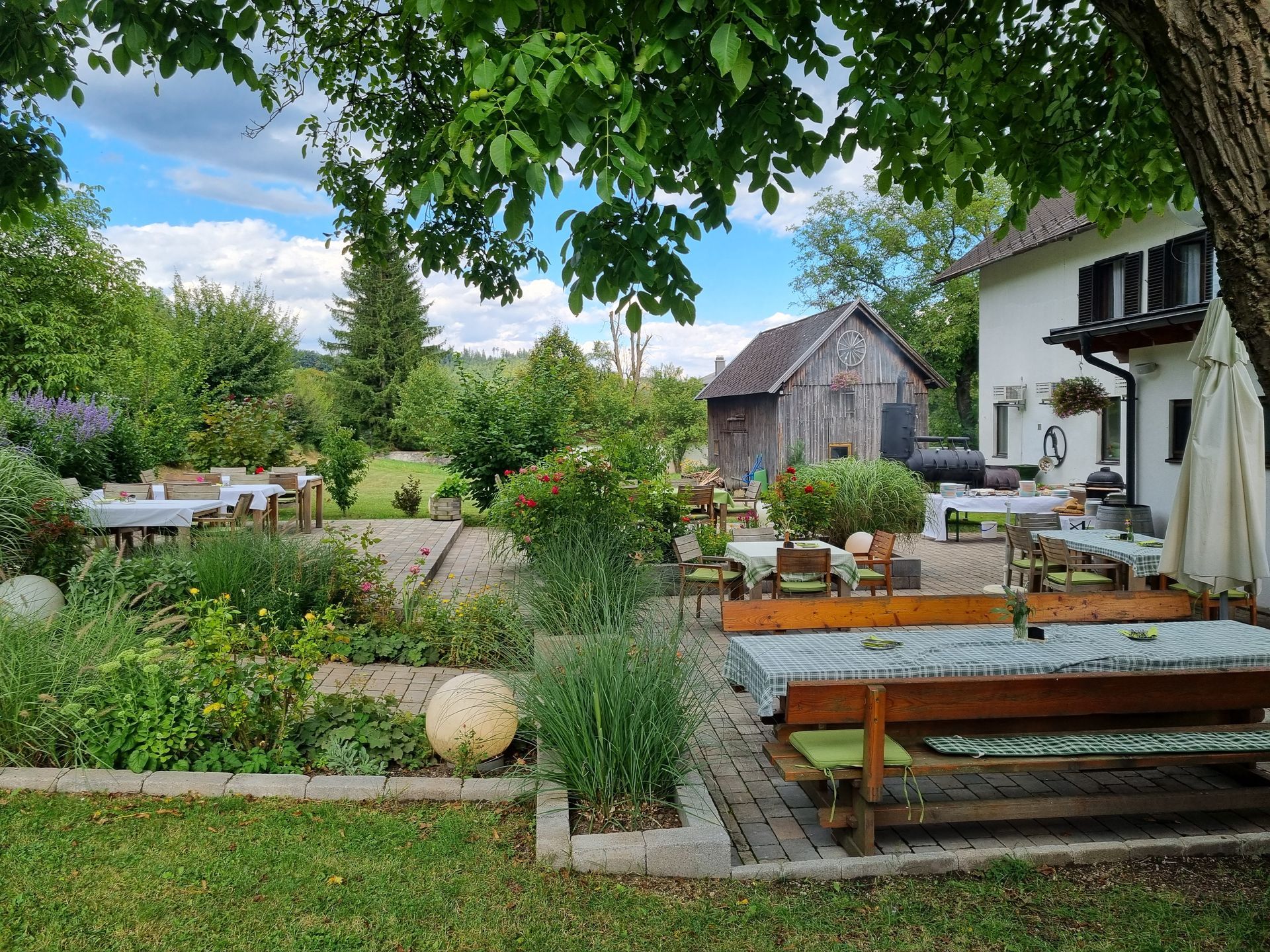 Hochzeitsempfang im Freien mit Tischen, die mit Blumenarrangements und Spitzentischdecken gedeckt sind.
