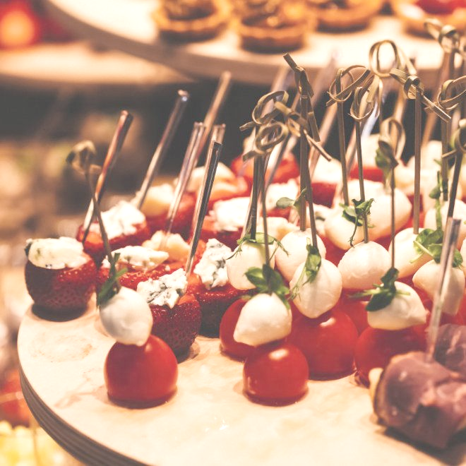 Vorspeisen auf Holzplatte: Tomaten, Mozzarella, Erdbeeren und Blauschimmelkäse.