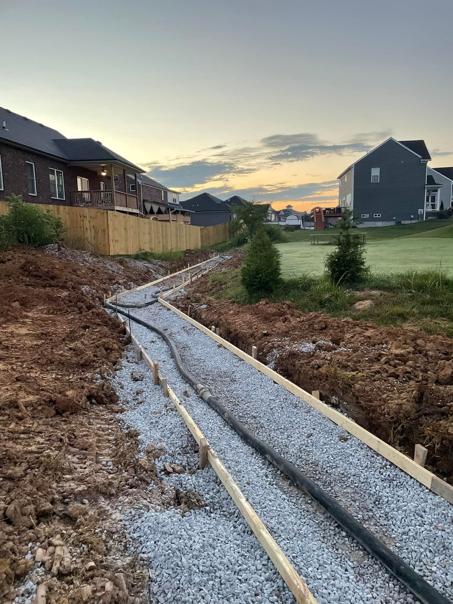 A dirt path leading to a house in a residential area.