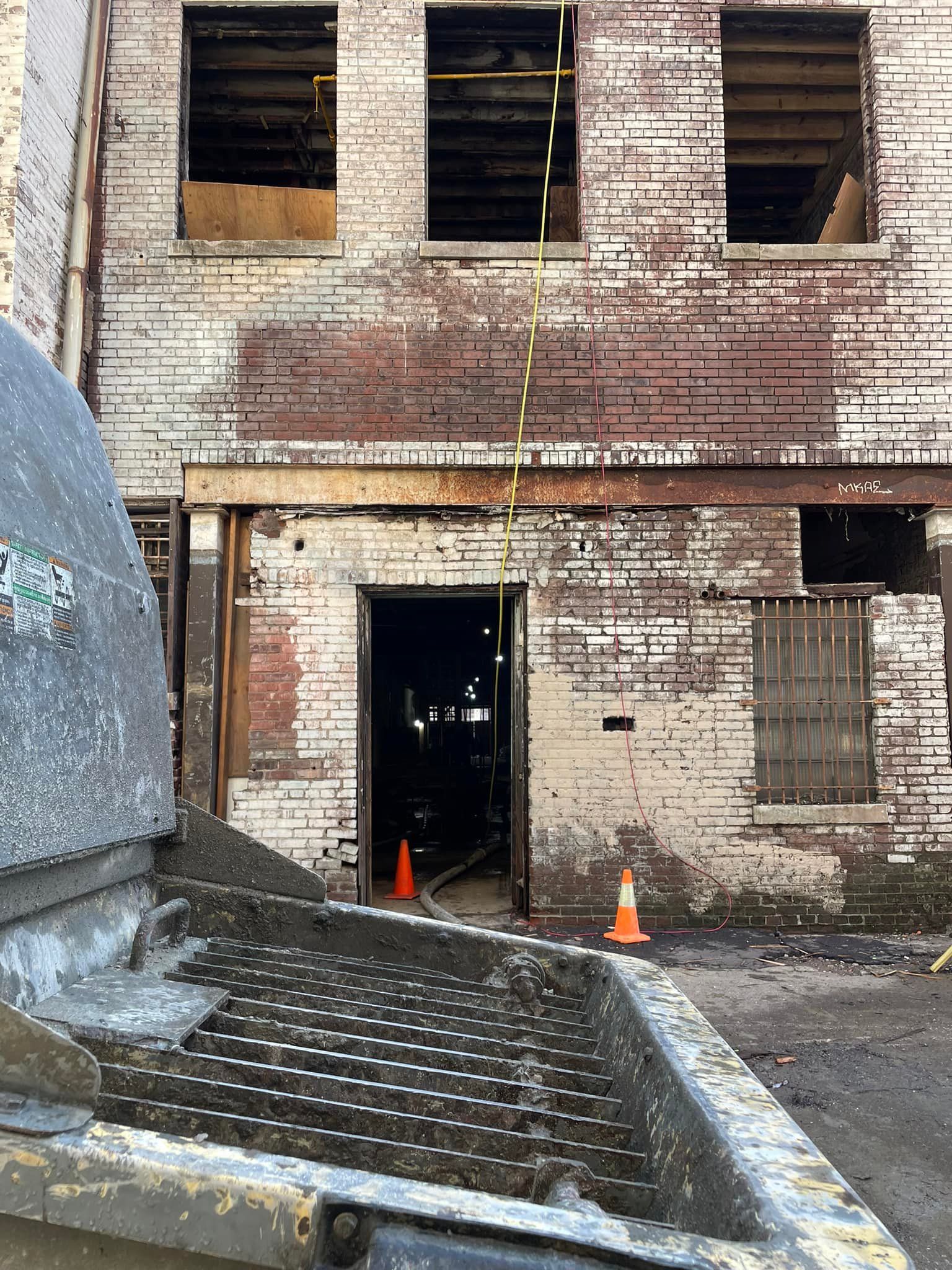 A truck is parked in front of an old brick building.