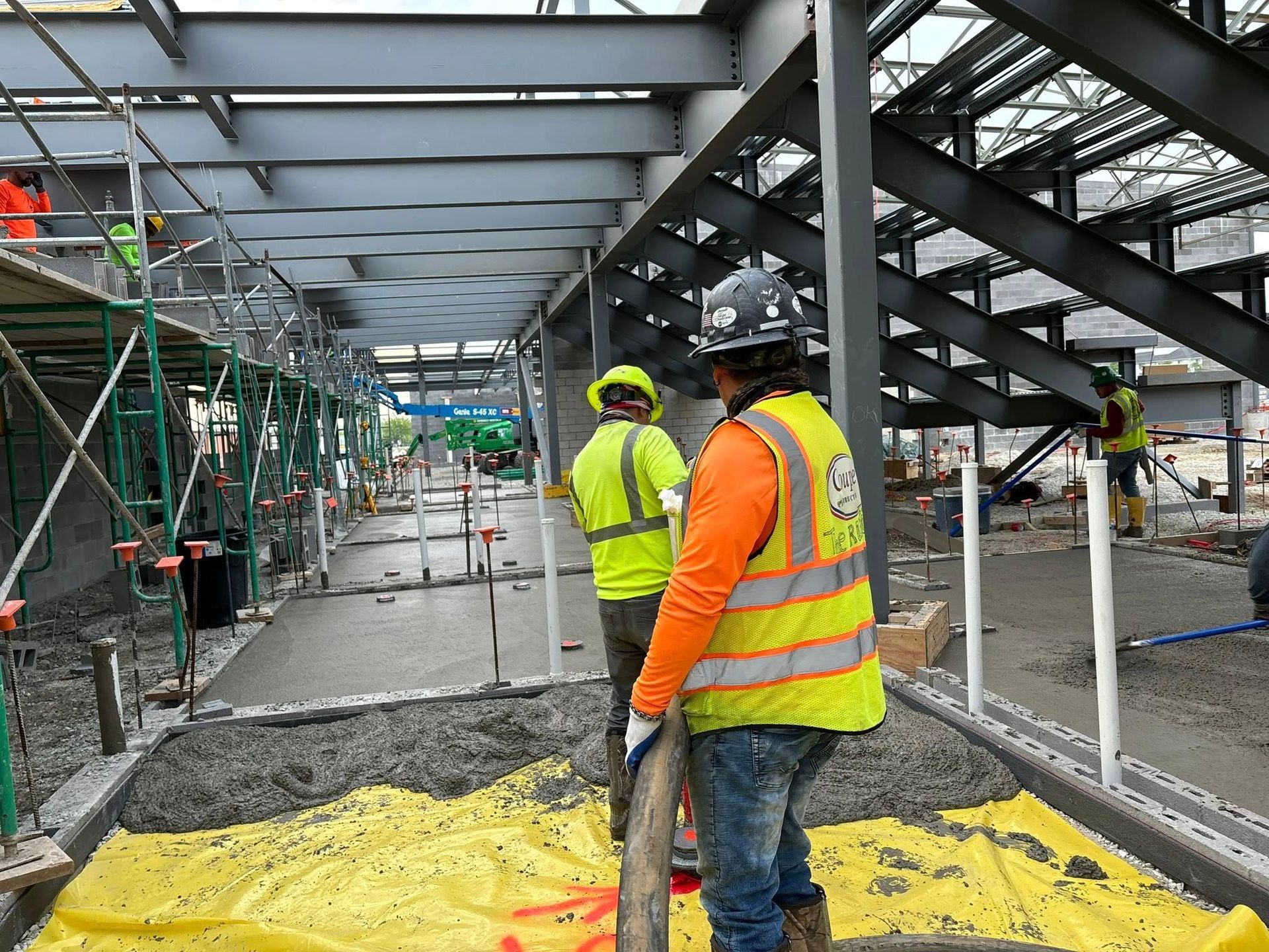Two construction workers are working on a building under construction