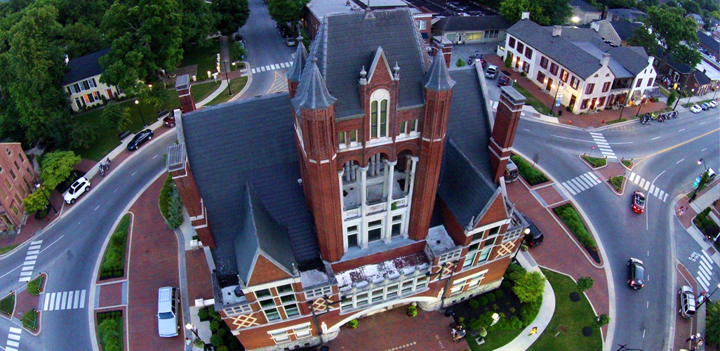 An aerial view of a large brick building in the middle of a city.