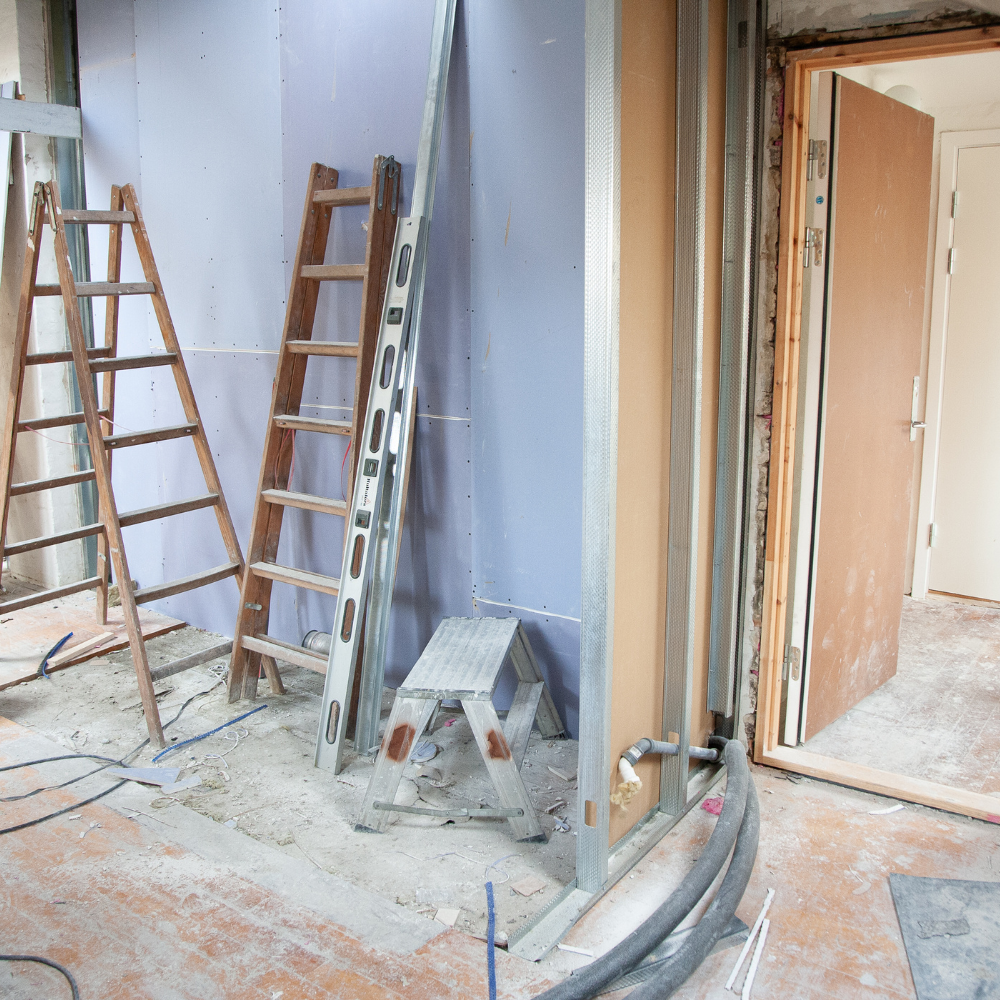A room under construction with a ladder and a stool