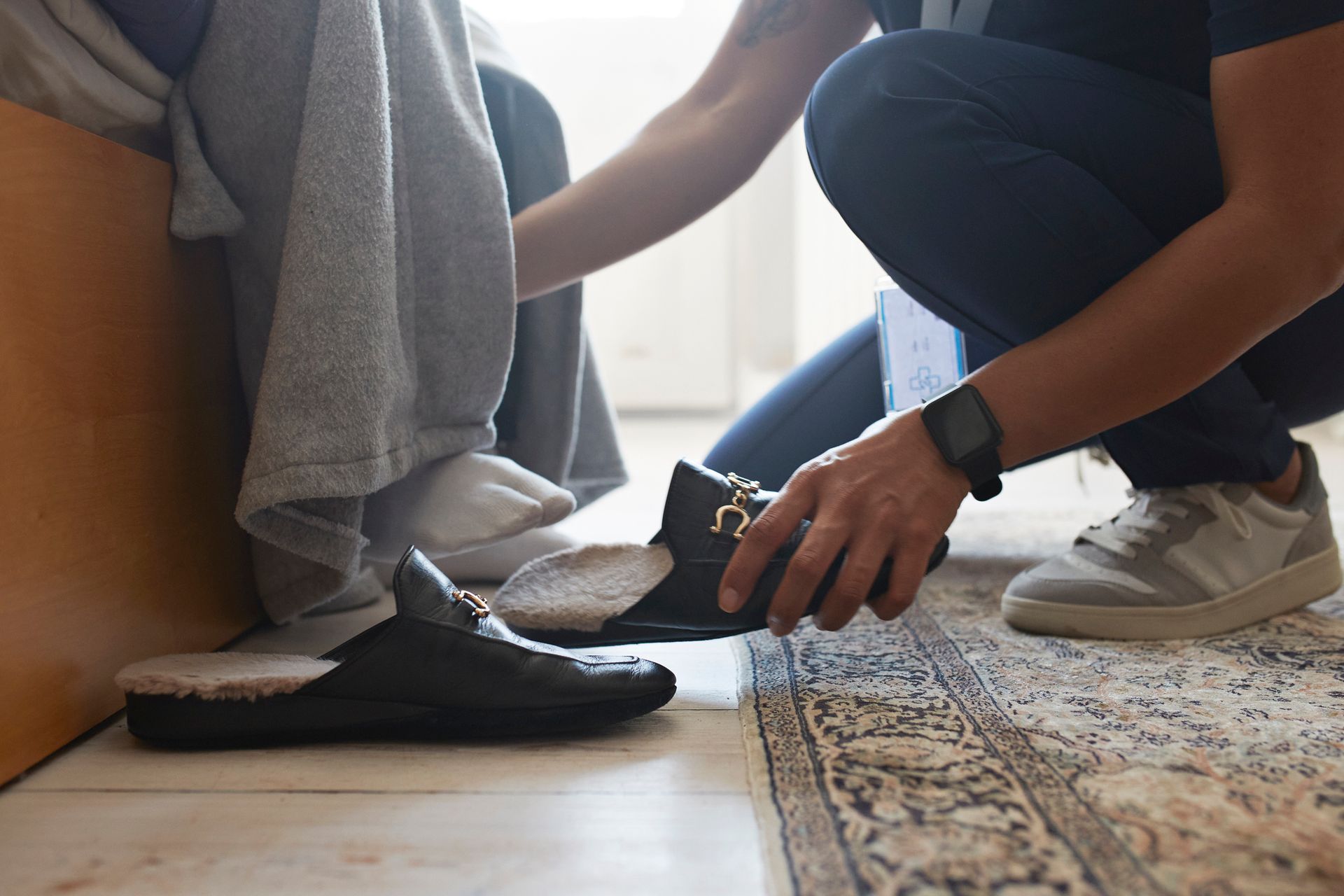 A man is helping a woman put on her shoes.
