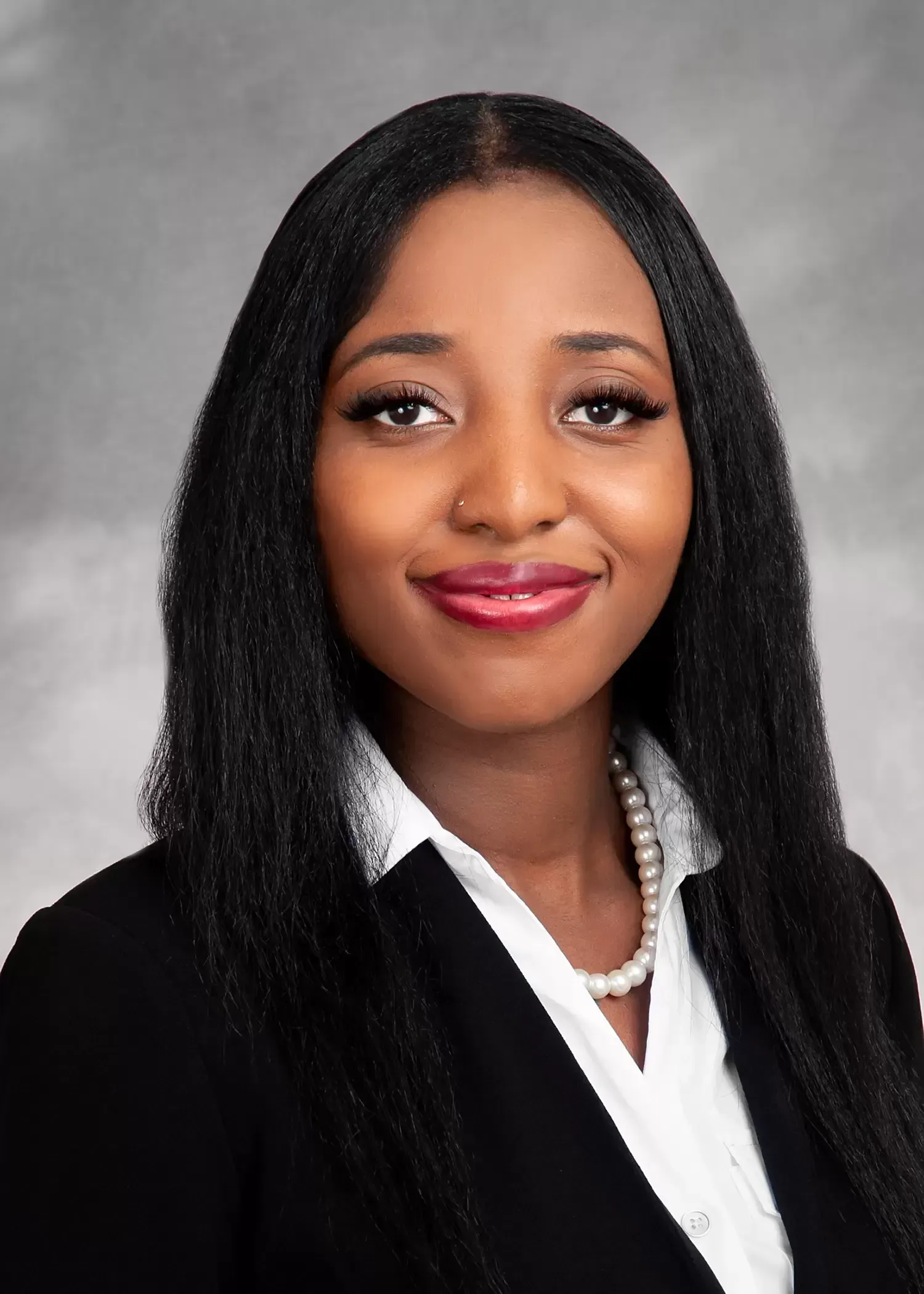 A woman in a black jacket and white shirt is smiling for the camera.