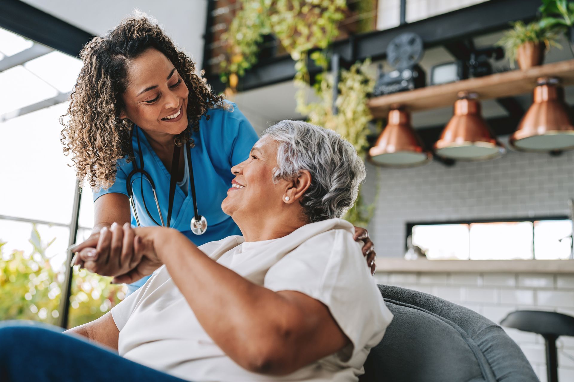 Healthcare worker assisting an older adult in a modern indoor setting.