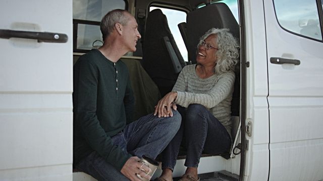 A man and a woman are sitting in the back of a van.