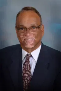 A man in a suit and tie is smiling for the camera.