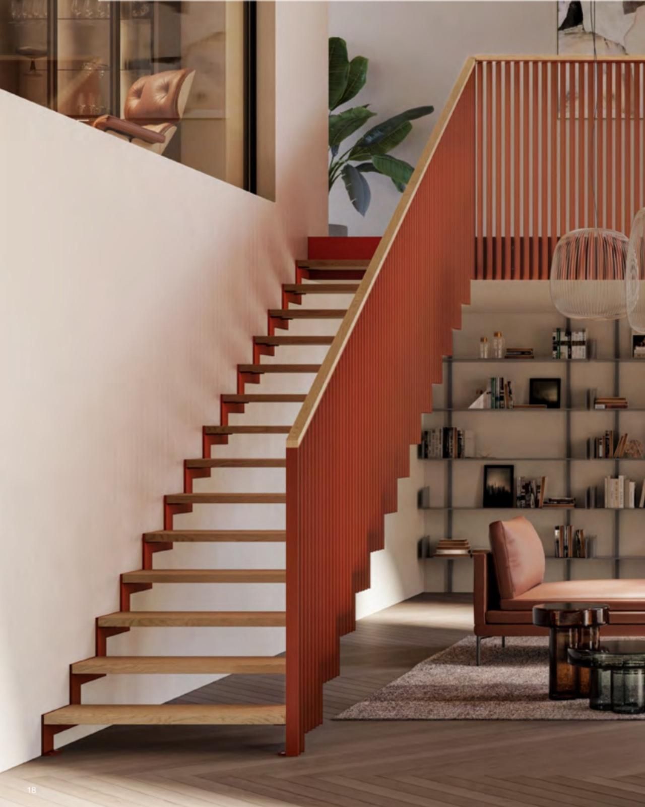 Interni moderni con scala in legno a vista, ringhiera rossa e accogliente zona giorno con scaffali e divano.