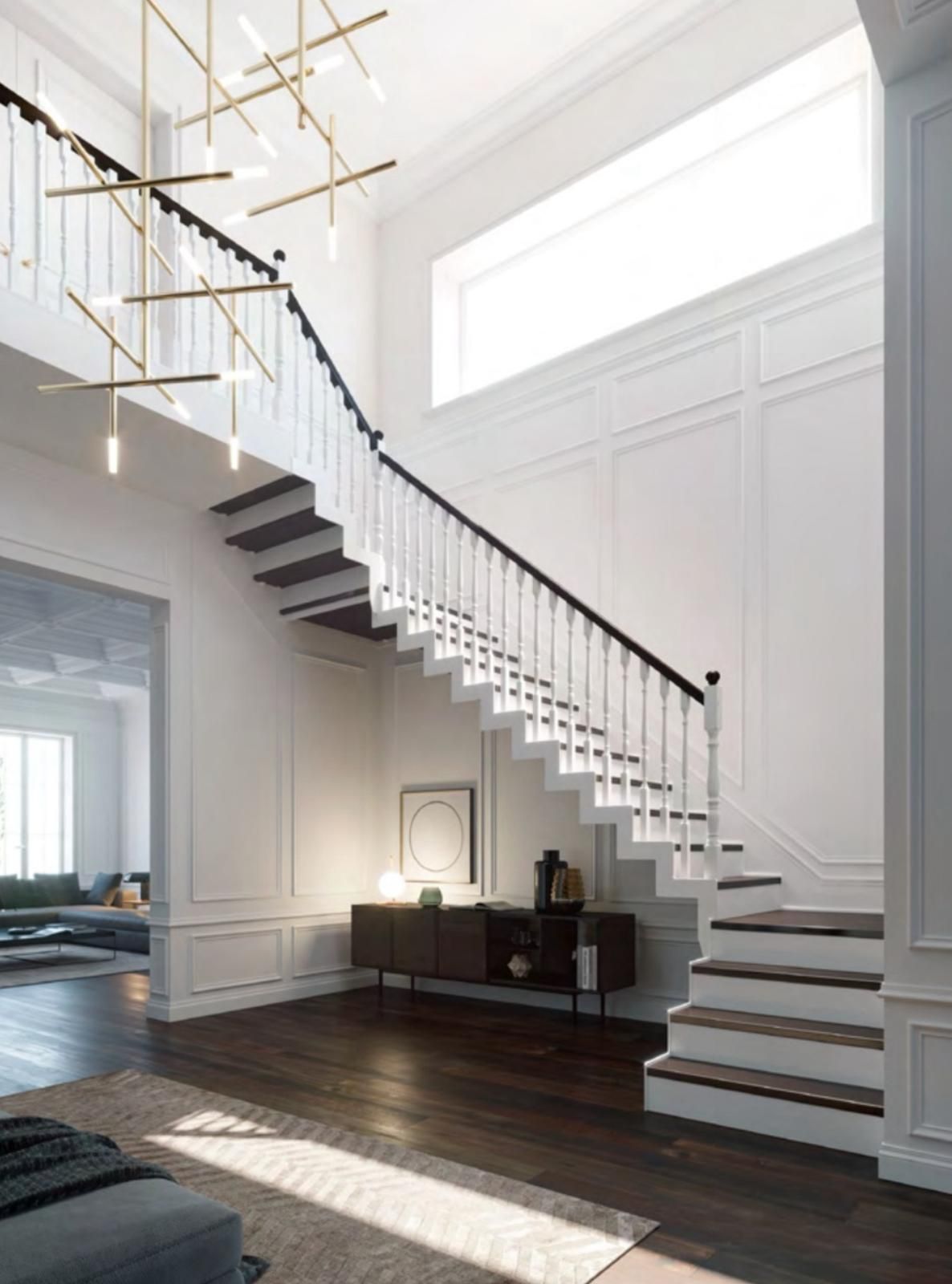 Atrio moderno e luminoso con scala sospesa, ringhiera nera e pavimenti in legno inondati di luce naturale.