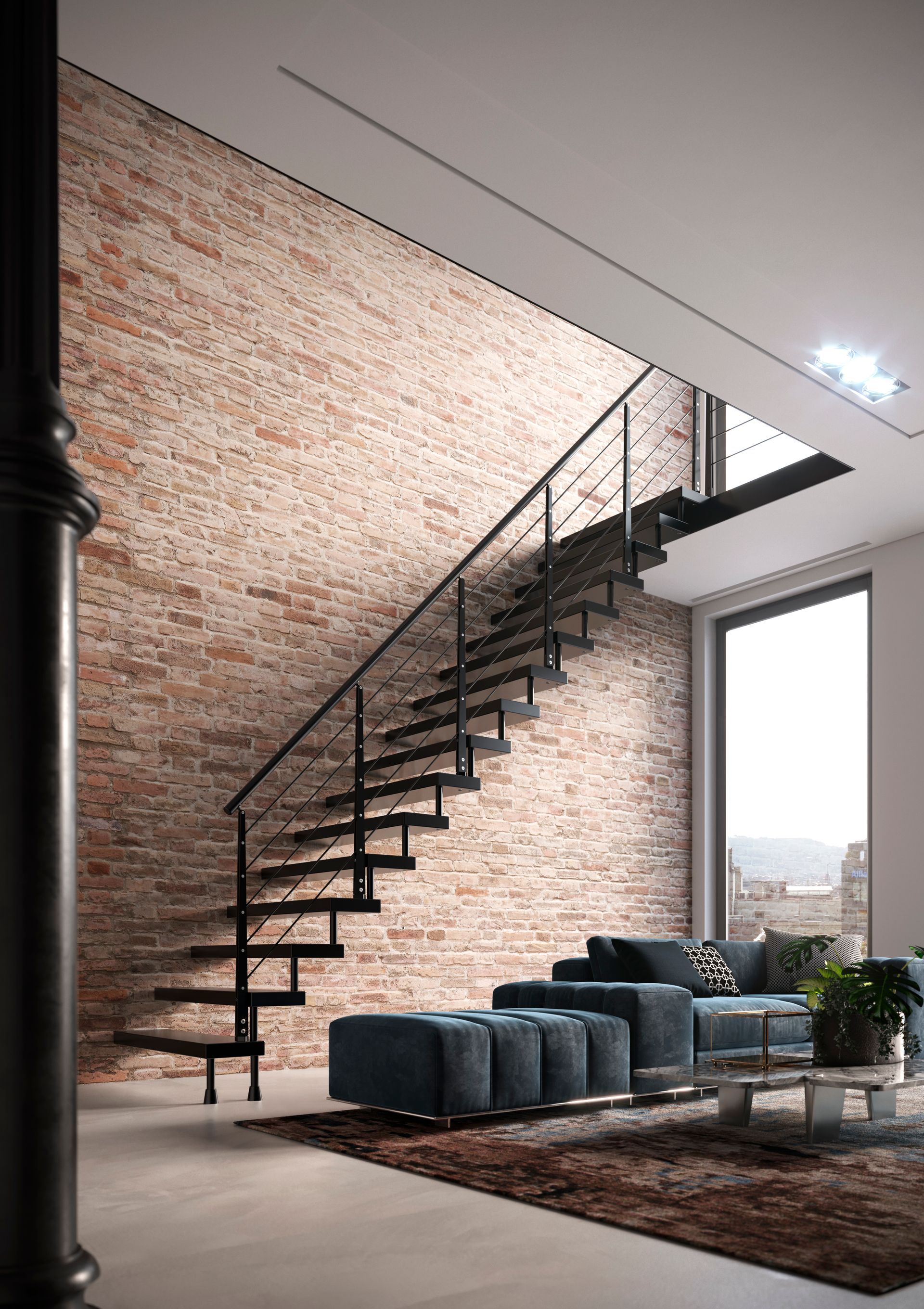 Soggiorno in stile loft moderno con mattoni a vista, scala nera, divani blu e ampie finestre.