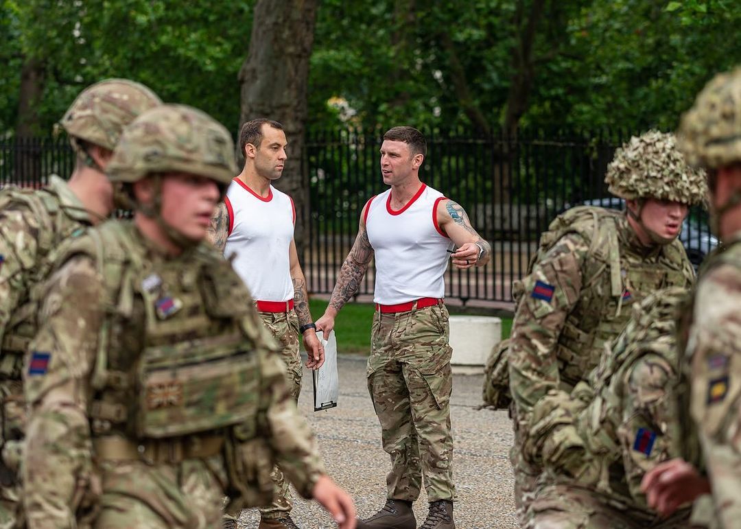 A group of soldiers are standing next to each other in a park.