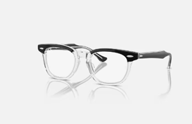 Un paio di occhiali trasparenti con montatura nera su una superficie bianca.