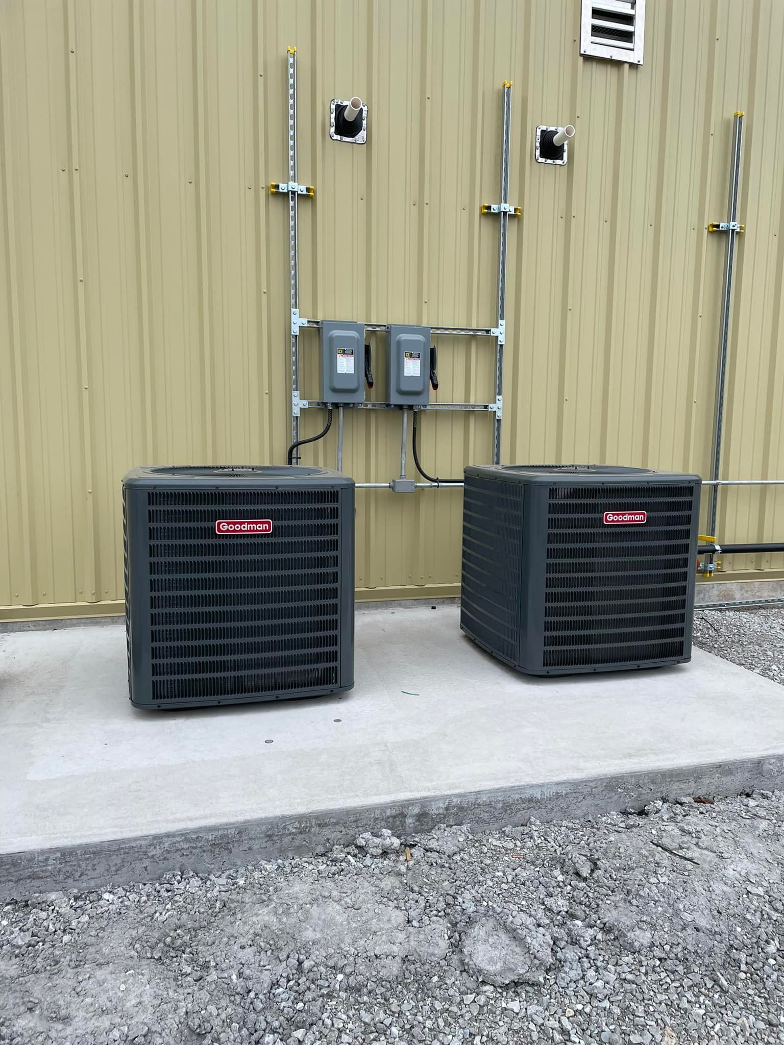 Two air conditioners are sitting outside of a building.