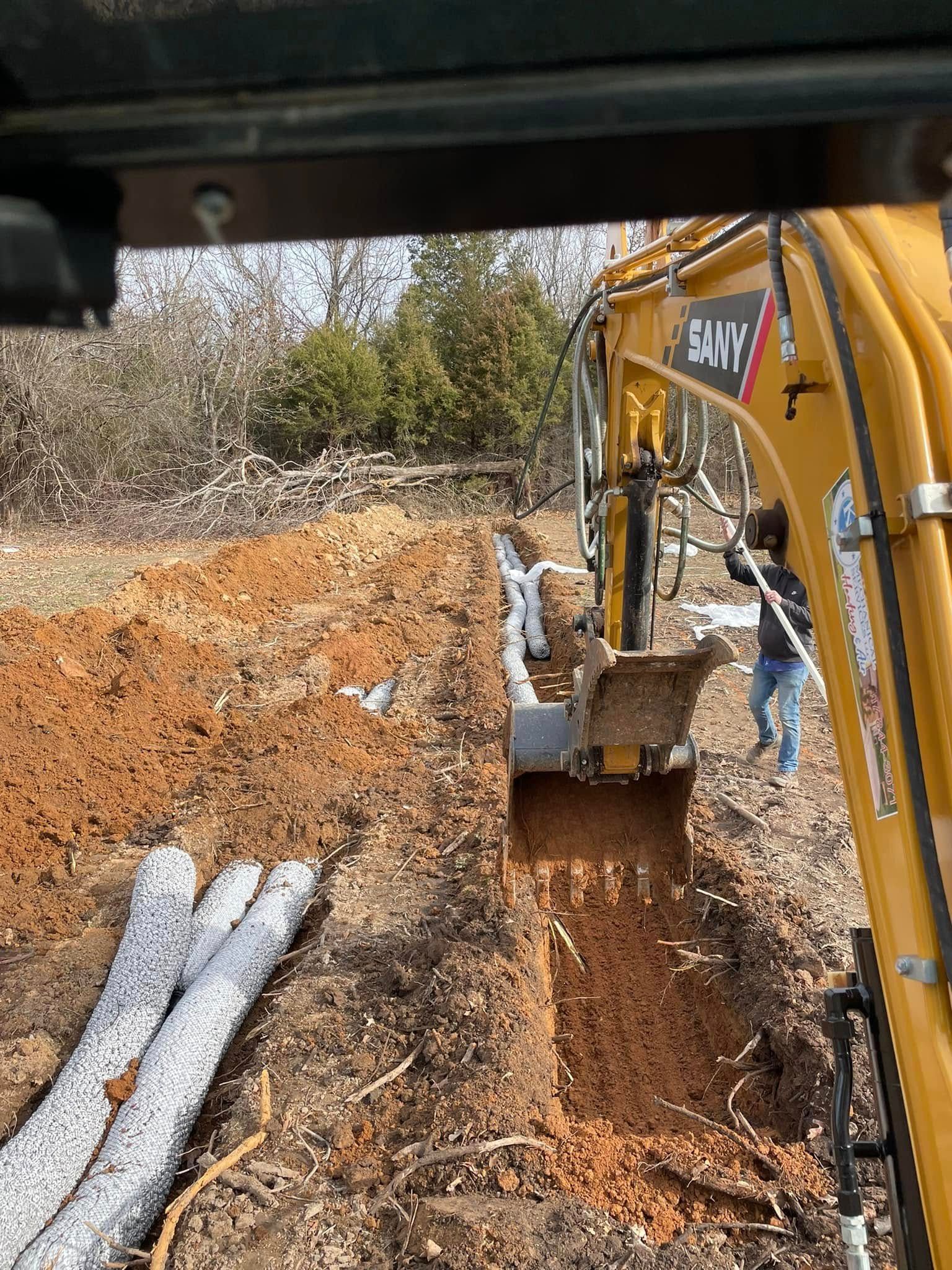 A yellow excavator is digging a hole in the dirt.