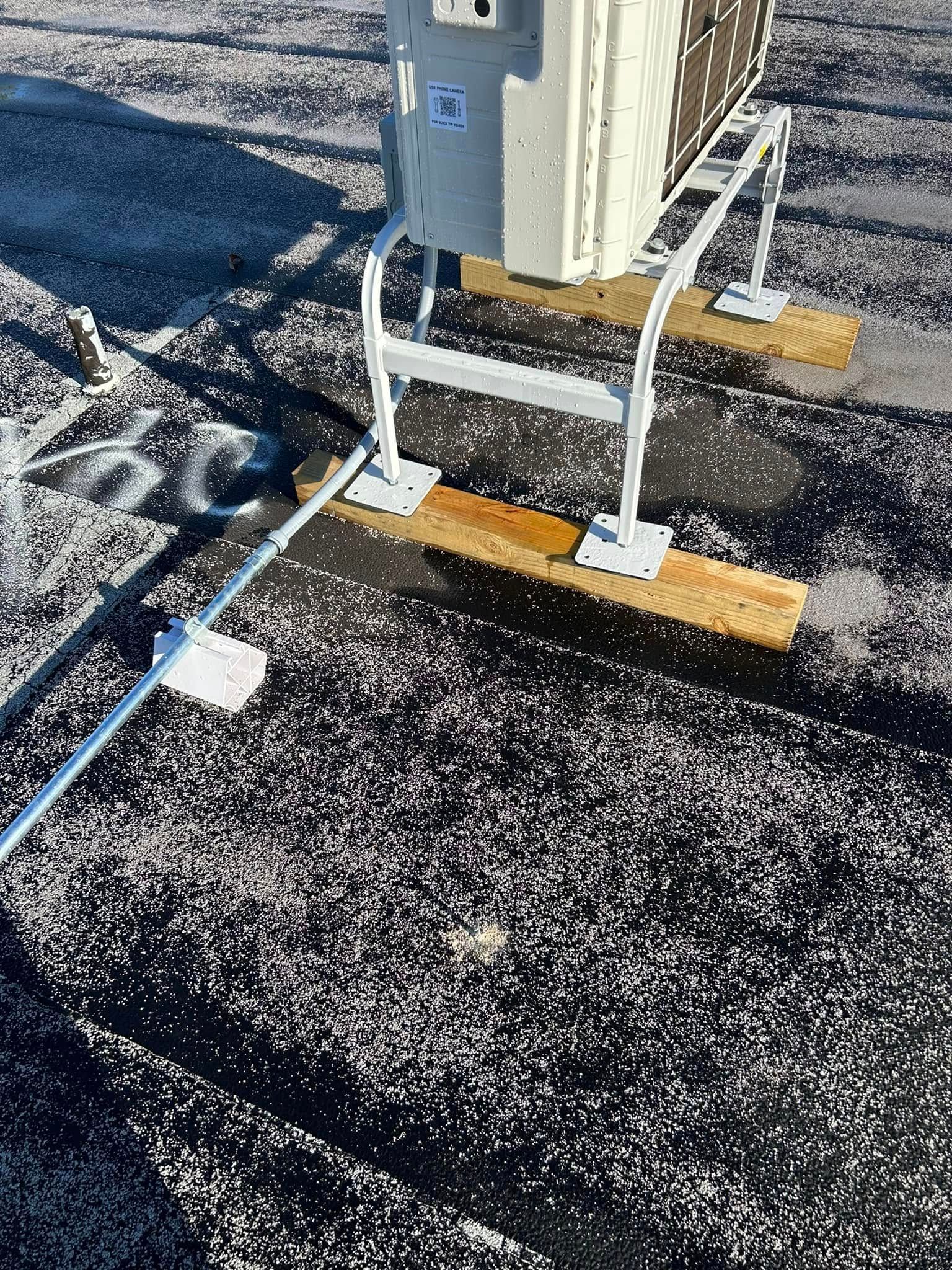 A large air conditioner is sitting on top of a roof.