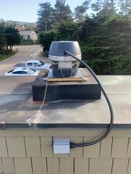 A chimney on top of a roof with a hose attached to it.