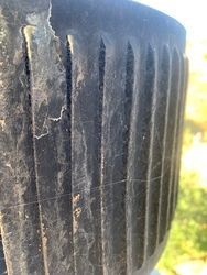 A close up of a black vase with a spider web on it.