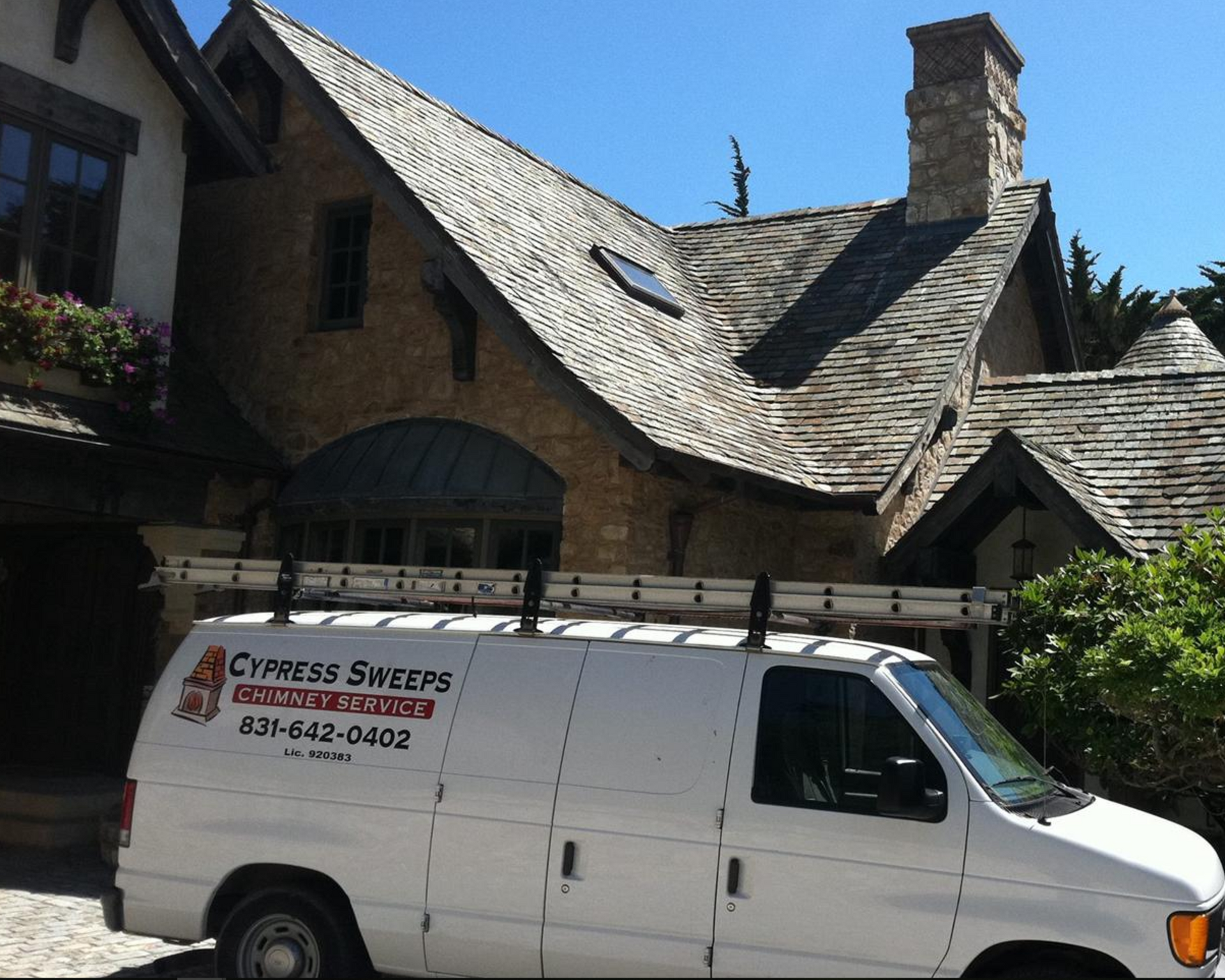 A cypress sweeps van is parked in front of a house