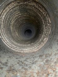 A close up of a metal pipe with a hole in the middle.