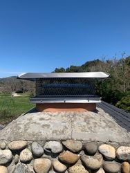 A chimney sitting on top of a pile of rocks.